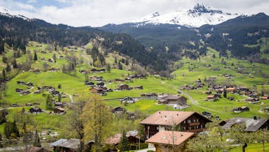 Charming village surrounded by lush green hills and snowy mountains in Interlaken, Switzerland.