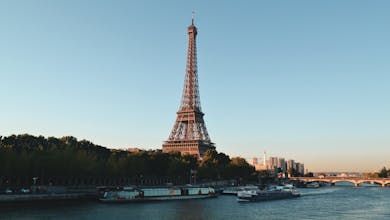 Scenic view of the Eiffel Tower and Seine River at sunset, showcasing iconic Parisian architecture.