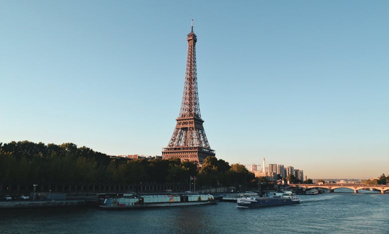 Scenic view of the Eiffel Tower and Seine River at sunset, showcasing iconic Parisian architecture.